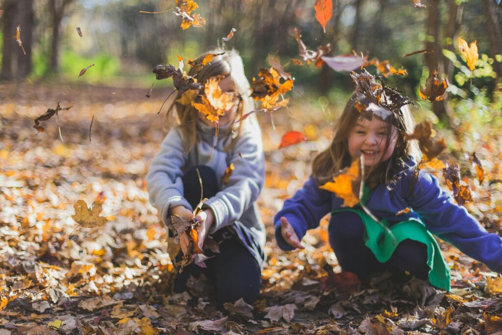 Foto Von Kindern, Die Mit Trockenen Blättern Spielen